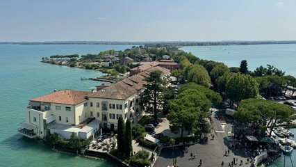 Unique Sirmione Peninsula Encircled by the Crystal Waters of Lake Garda, Italy. This iconic Italian destination combines historic charm with natural beauty, featuring medieval buildings, lush greenery