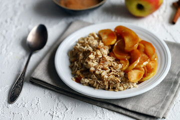 A bowl of oatmeal with caramelized apples and cinnamon.