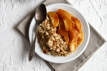 A bowl of oatmeal with caramelized apples and cinnamon.