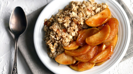 A bowl of oatmeal with caramelized apples and cinnamon.