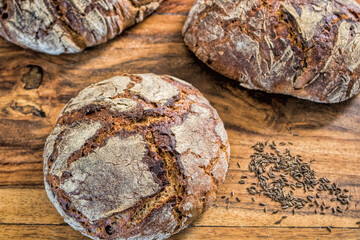 drei kuemmelbrote auf einem holztisch