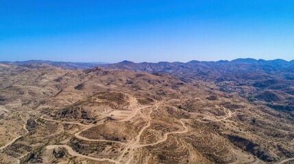 Aerial View of Barren Hills Under Bright Sunlight