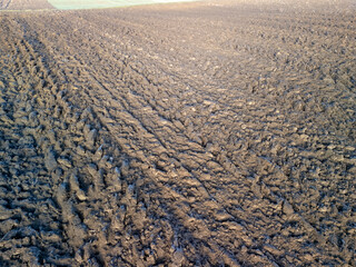 A close-up shot of freshly plowed soil, showcasing rich dark earth texture and pattern. Ideal for agricultural and nature-themed projects.