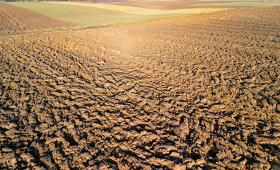 Aerial view of dry cracked soil in agricultural land, highlighting drought and farming challenges...