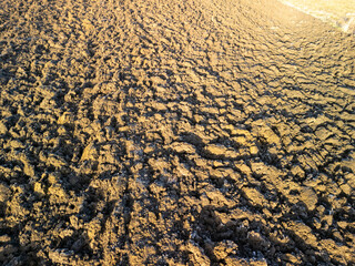 A close-up view of freshly plowed soil showing rich textures and patterns under sunlight. Ideal for agricultural themes.