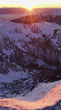 Breathtaking sunrise over the snow-capped Alps in stunning vertical format