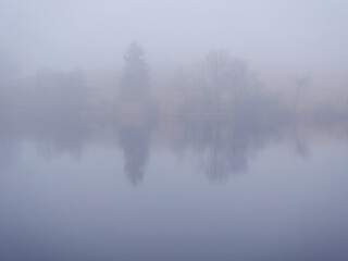 A mystical mining pond in the Harz. Fog, reflections, and horizons in winter create an enigmatic atmosphere, perfect for diverse themes.