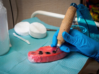 Close-up of a tattoo machine with pigments showing the details of the device and the colors of the...