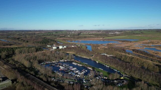 Aerial drone footage descending over Lemonroyd Marina and Waterside beside the Aire and Calder Navigation. Canal boats and house boats moored. West Yorkshire, UK