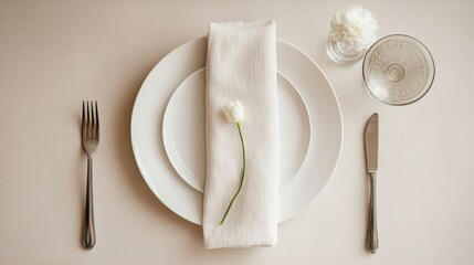 Pristine white table setting with porcelain plate, silver fork, and linen napkin