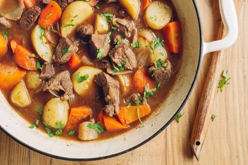 Homemade Beef Stew with Carrots, Potatoes, and Fresh Parsley in a Rustic Dutch Oven