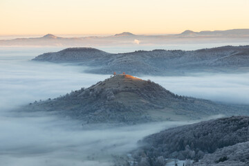 Blick vom Breitenstein, Ochsenwang, Schwäbische Alb auf die drei Kaiserberge - Hohenstaufen, Stuifen und Rechberg. Im Vordergrund die Limburg bei Weilheim Teck im Winter zum Sonnenaufgang mit Nebel.