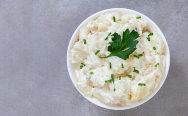 A bowl of mashed potatoes with parsley on top