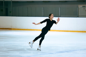Girl figure skater trains on skates on the ice.