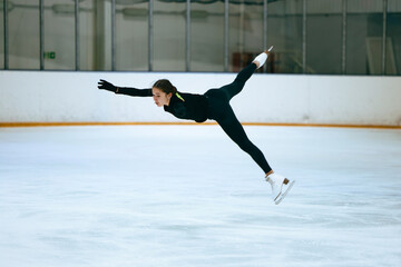 Girl figure skater trains on skates on the ice.