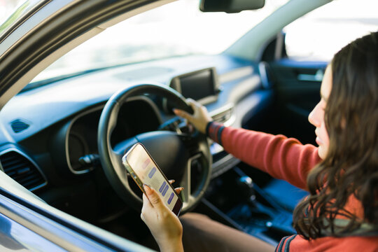 Teenager driving a car while holding and using a smartphone, representing distracted driving and road safety issues