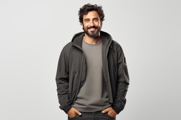 Obraz premium A smiling man wearing a casual hoodie, radiating confidence and warmth against a neutral backdrop.