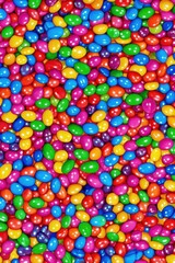 Fototapeta premium Colorful assortment of candy-coated chocolates scattered across a vibrant background creating a joyful and festive atmosphere perfect for celebrations or special occasions