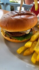 Burger hamburger z wołowiną i serem i patyczkiem oraz frytki