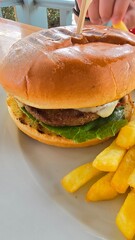 Burger hamburger z wołowiną i serem i patyczkiem oraz frytki