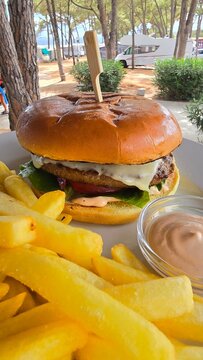 Burger hamburger z wołowiną i serem i patyczkiem oraz frytki