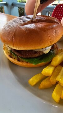 Burger hamburger z wołowiną i serem i patyczkiem oraz frytki