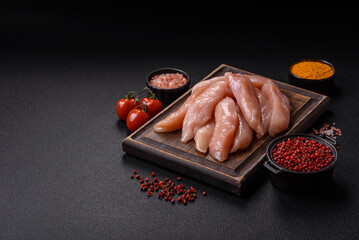 Raw chicken fillet cut into strips with spices and herbs