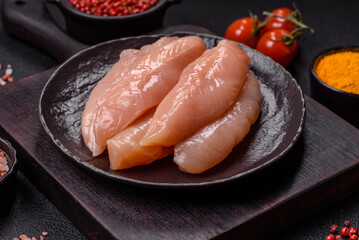 Raw chicken fillet cut into strips with spices and herbs
