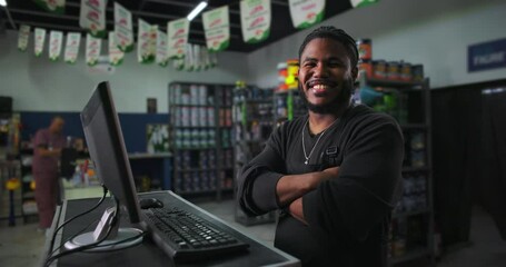 One Black male retail employee with arms crossed, confidently standing at counter, shop interior visible, engaging and professional customer service approach