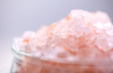 Fototapeta premium Himalayan salt, pink Himalayan salt crystals close up. Pink coarse salt crystals macro shot, over pastel blue background