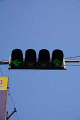 A traffic signal with four lights displaying green left-turn arrows which is a device used to...