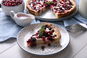 Piece of delicious currant pie served on white wooden table