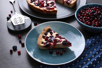Piece of delicious currant pie and fresh berries on grey table