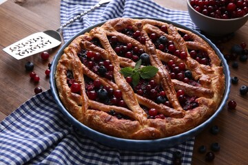 Delicious currant pie with fresh berries on wooden table