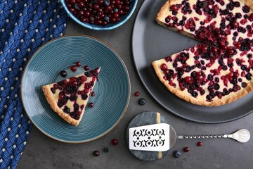 Delicious currant pie and fresh berries on grey table, flat lay