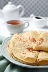 Delicious crepes served on white table, closeup