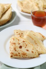 Tasty crepes served on white table, closeup