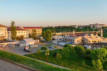 Panoramic view of the city on a sunny summer day. A road bridge crosses the river in the city.