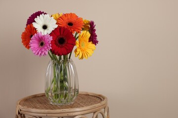Bouquet of beautiful gerbera flowers on table against beige background. Space for text