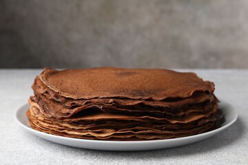 Delicious chocolate crepes on light grey table, closeup