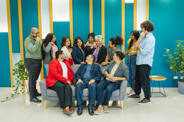 A diverse group of people gathers around a sofa, sharing laughter and animated interaction in a...