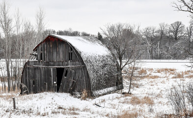 weathered old wood barn in the winter snow