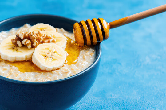 Creamy oatmeal topped with banana, honey, and walnuts
