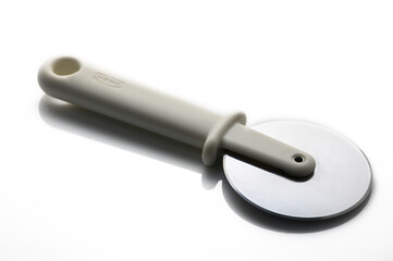 Elegant and sleek pizza cutter resting on a reflective surface amidst soft lighting