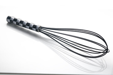 Whisk resting on a smooth surface awaiting the start of a culinary adventure in a bright kitchen