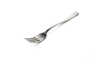 Unique silver fork with elongated tines resting on a plain white surface at midday
