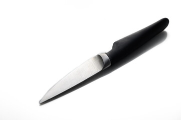 Sleek kitchen knife resting on white background with elegant shadows showcasing its design and craftsmanship