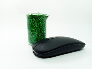 green masterbatch, polymer carries pigment in a container with isolated glass mouse on white...