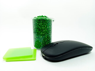 green masterbatch, polymer carries pigment in a container with isolated glass mouse on white...