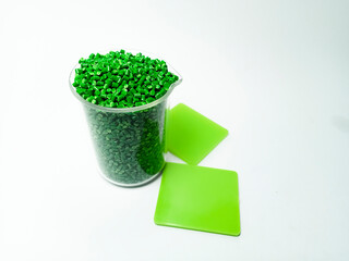 green masterbatch, polymer carries pigment in isolated glass container with white background,...